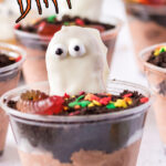 A closeup of an edible dirt cup with a cookie ghost in it for Pinterest.