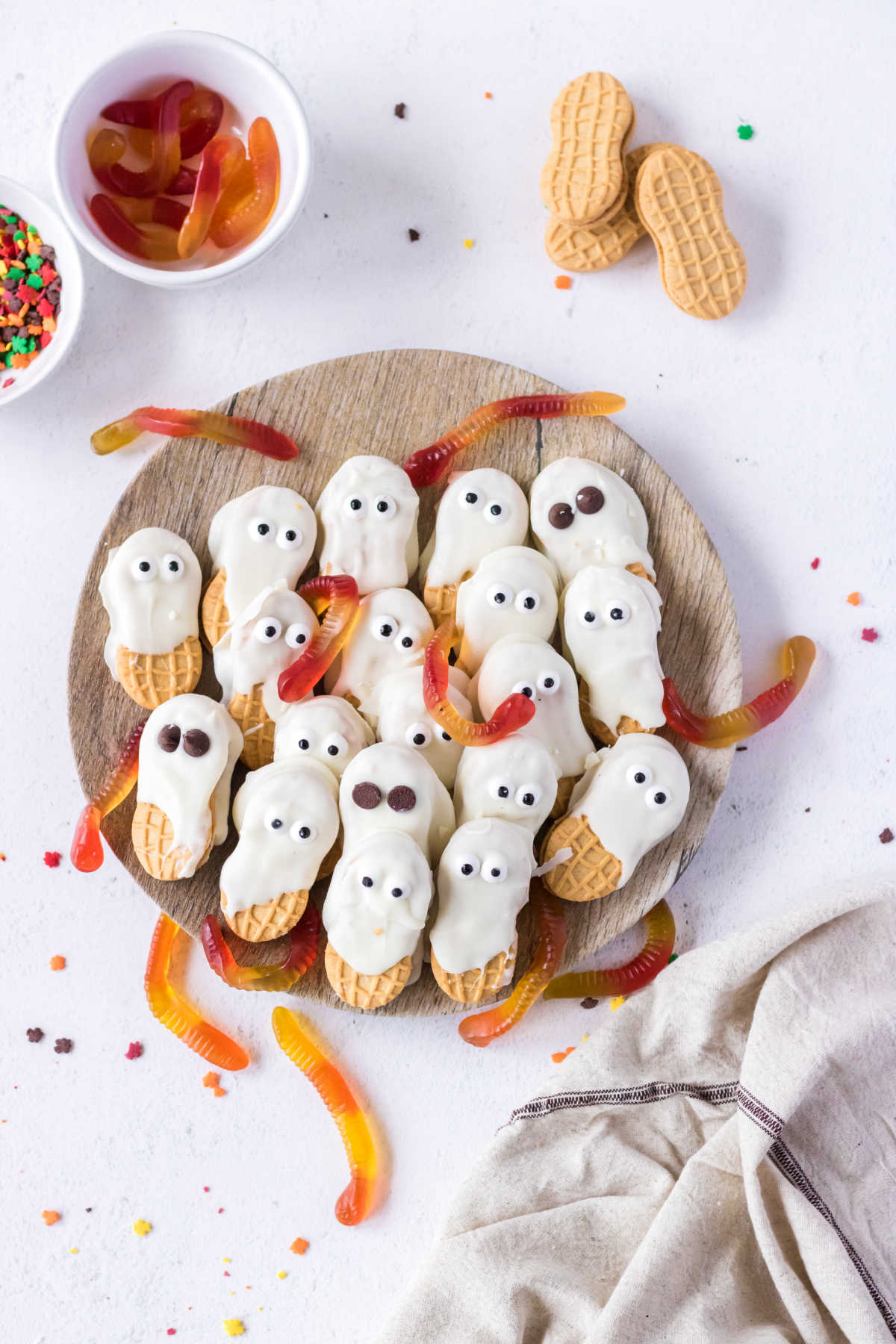 Two kinds of Nutter Butter ghost cookies. One has candy eyes and one has chocolate chip eyes.