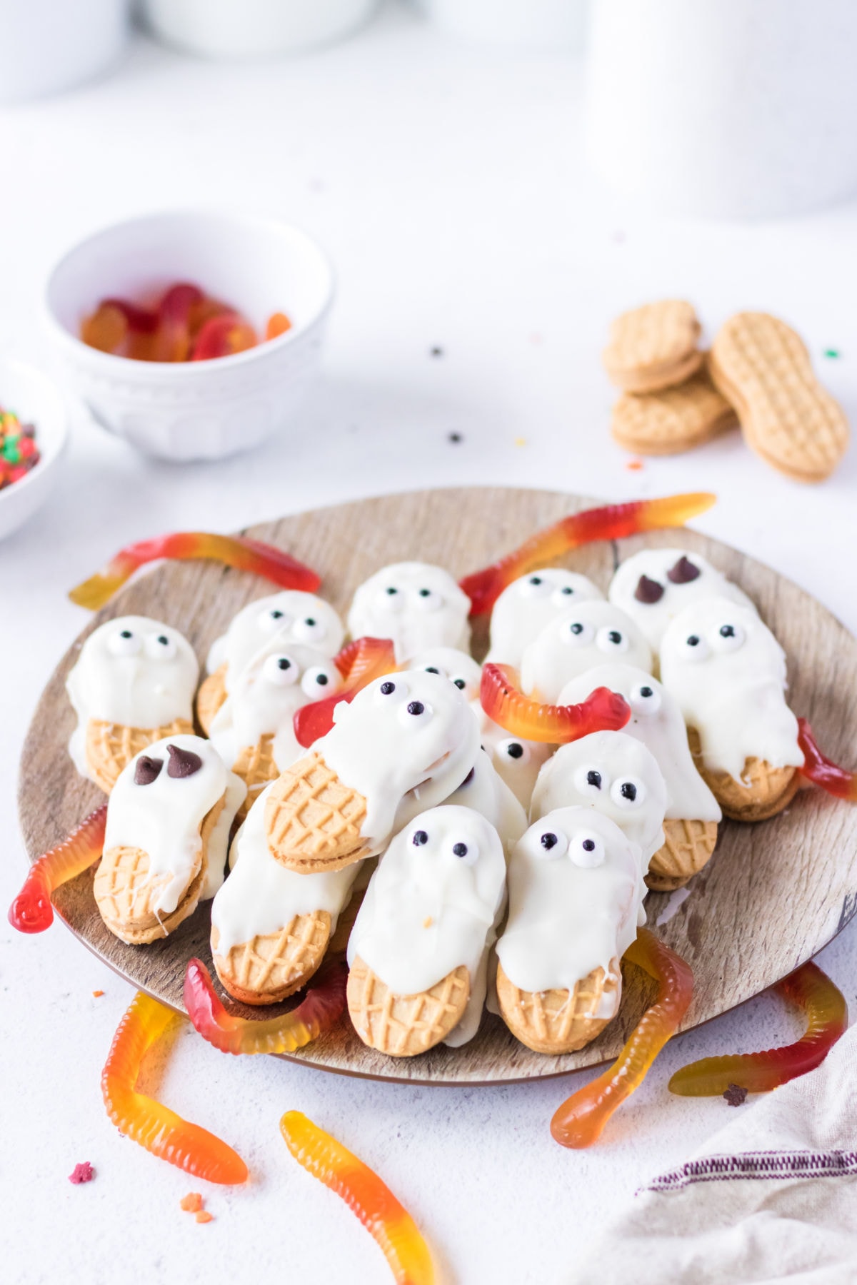 Nutter Butter Halloween cookies on a plate with gummy worms.