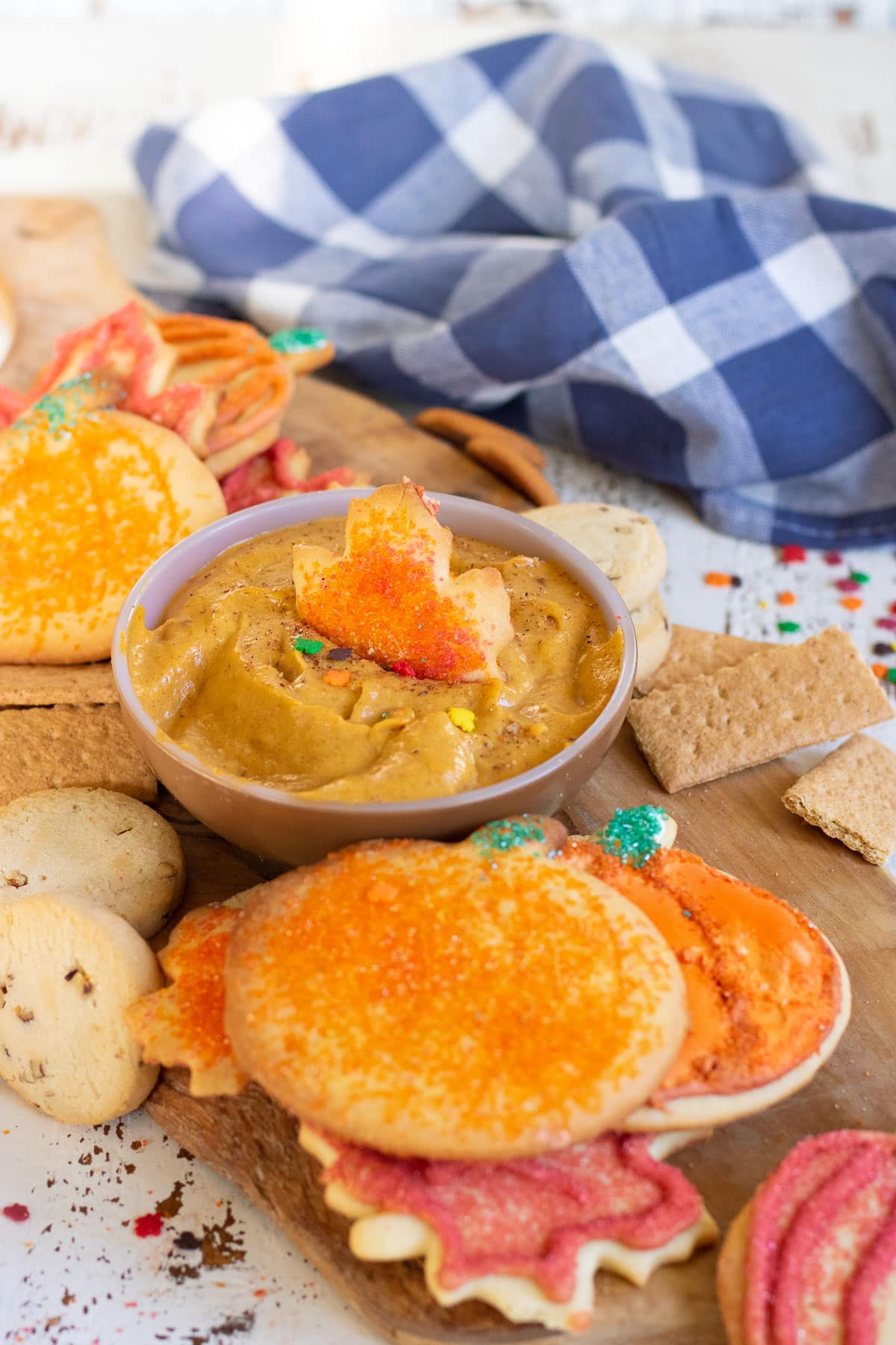 Pumpkin dip in a bowl surrounded by cookies.