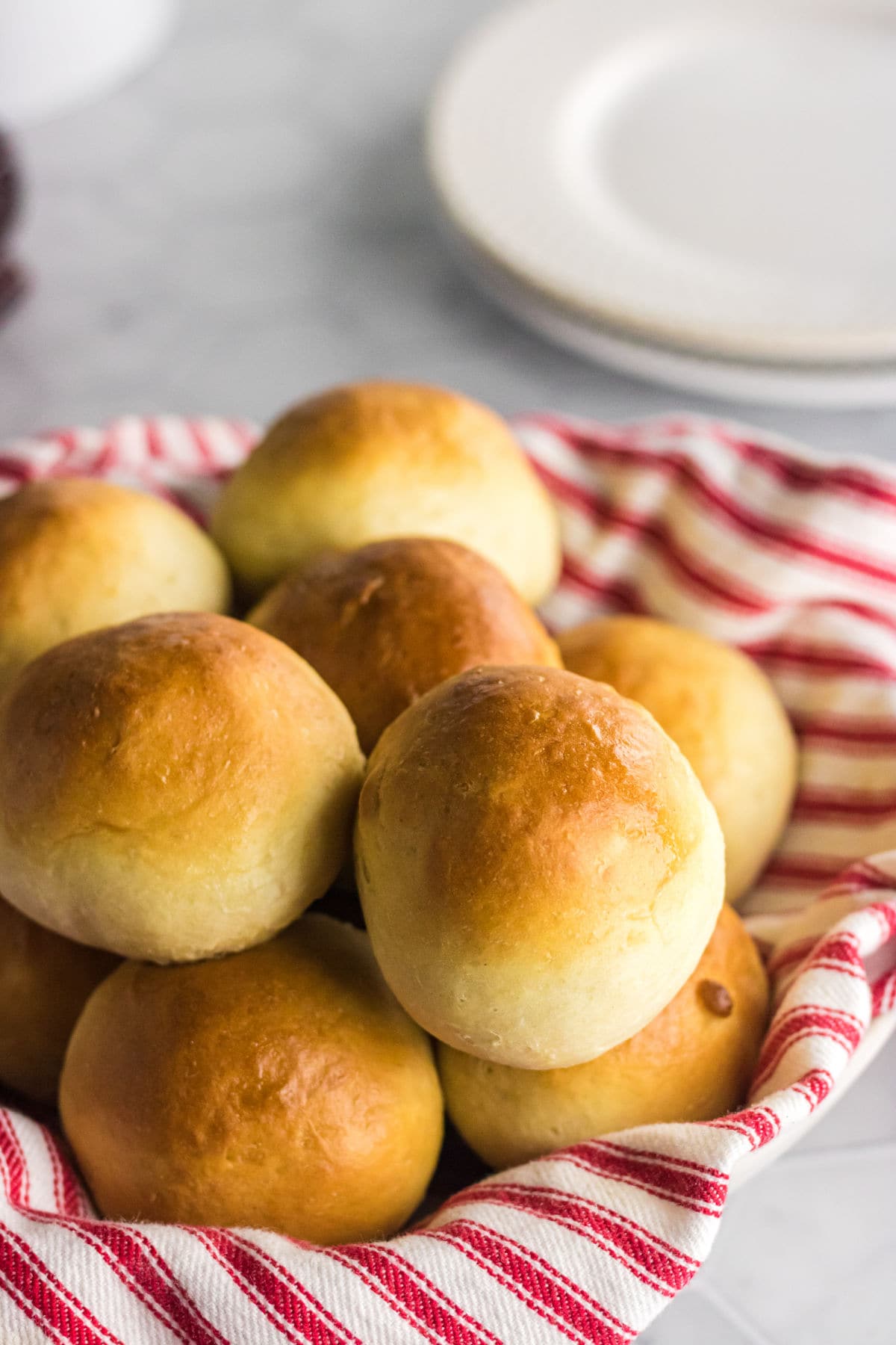 A batch of warm dinner rolls in a basket.