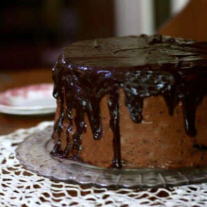 A whole chocolate layer cake with a dark chocolate drizzle.
