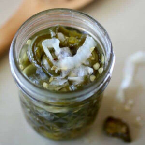 Overhead view of candied jalapenos in a jar.