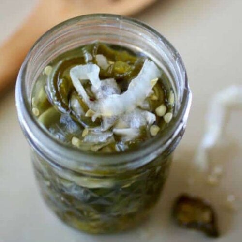 Overhead view of candied jalapenos in a jar.