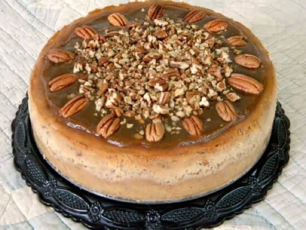 A whole cheesecake showing the pecan topping.