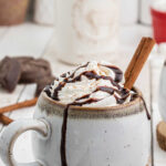 A mug of hot chocolate on a table with a text overlay for Pinterest.