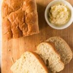 Overhead view of sliced bread on a cutting board with text overlay for Pinterest