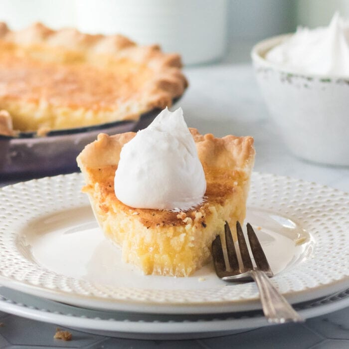 Buttermilk pie on a white plate with a fork.