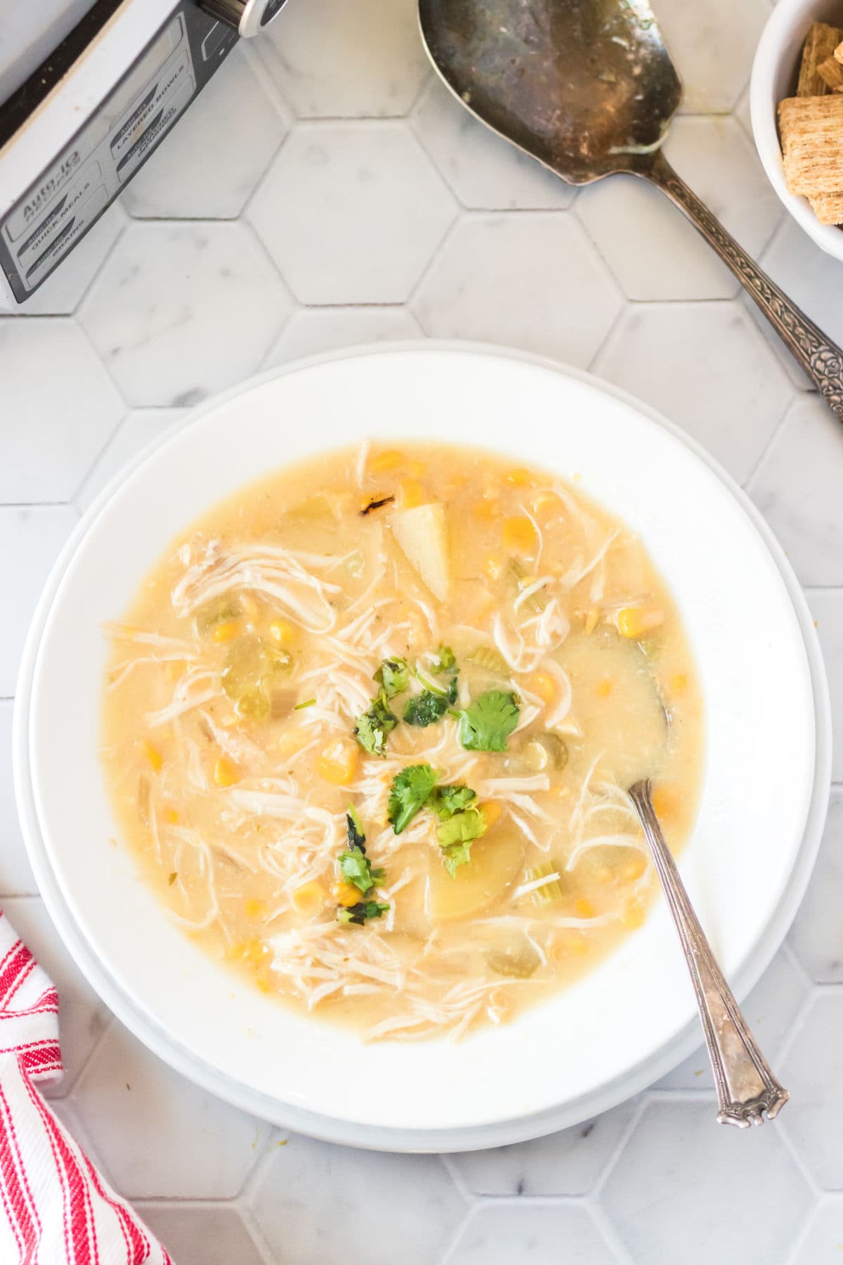 Chicken Corn chowder in a white bowl with a spoon.