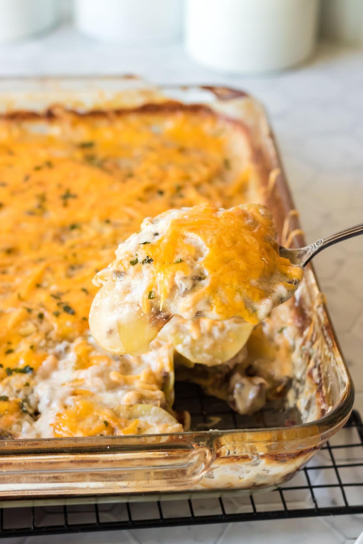 Hamburger potato casserole with a spoon taking a serving out.