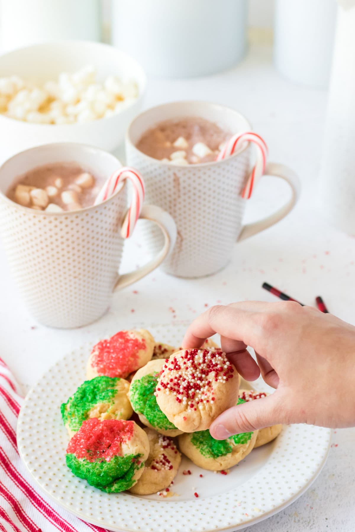 Hand picking up Christmas cookie from plate