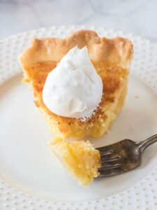A slice of buttermilk pie with a piece on a fork.