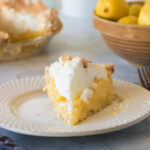 Old fashioned lemon meringue pie on white plate.