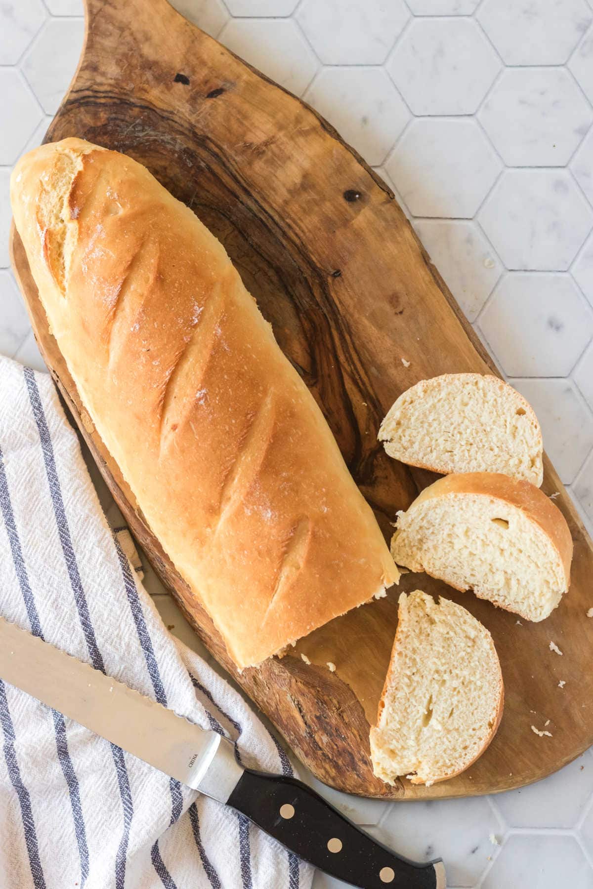 Homemade baguette with slices next to it.