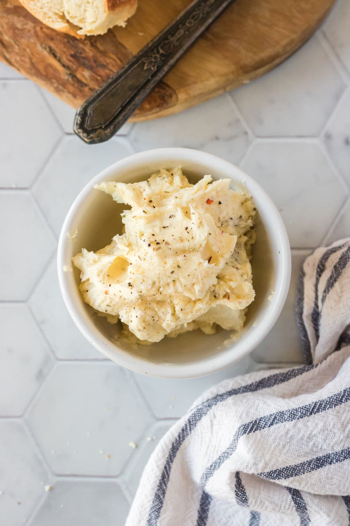 Overhead shot of garlic butter in a white bowl.