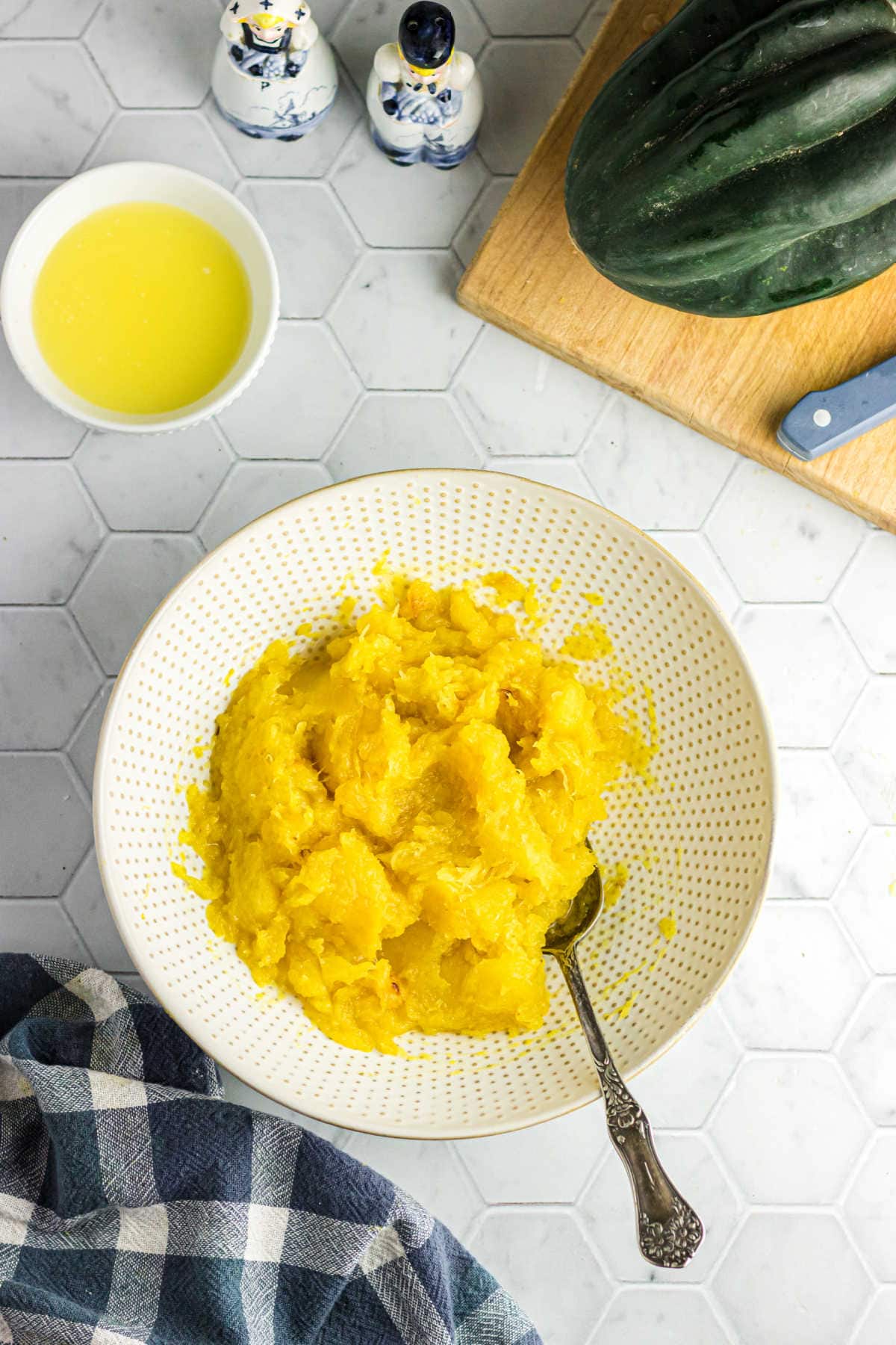 Overhead view of the finished acorn squash in a bowl with a spoon.