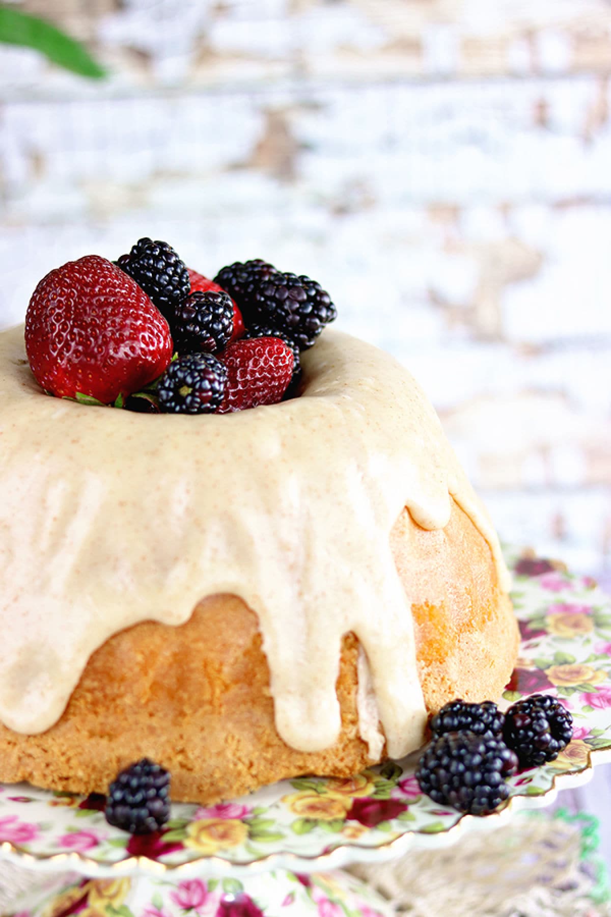 Side view of a buttermilk pound cake with glaze running down the side.