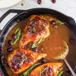 Overhead view of the chicken in a skillet with text overlay for Pinterest.