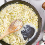 Overhead view of skillet with finished cabbage in it. Feature image.