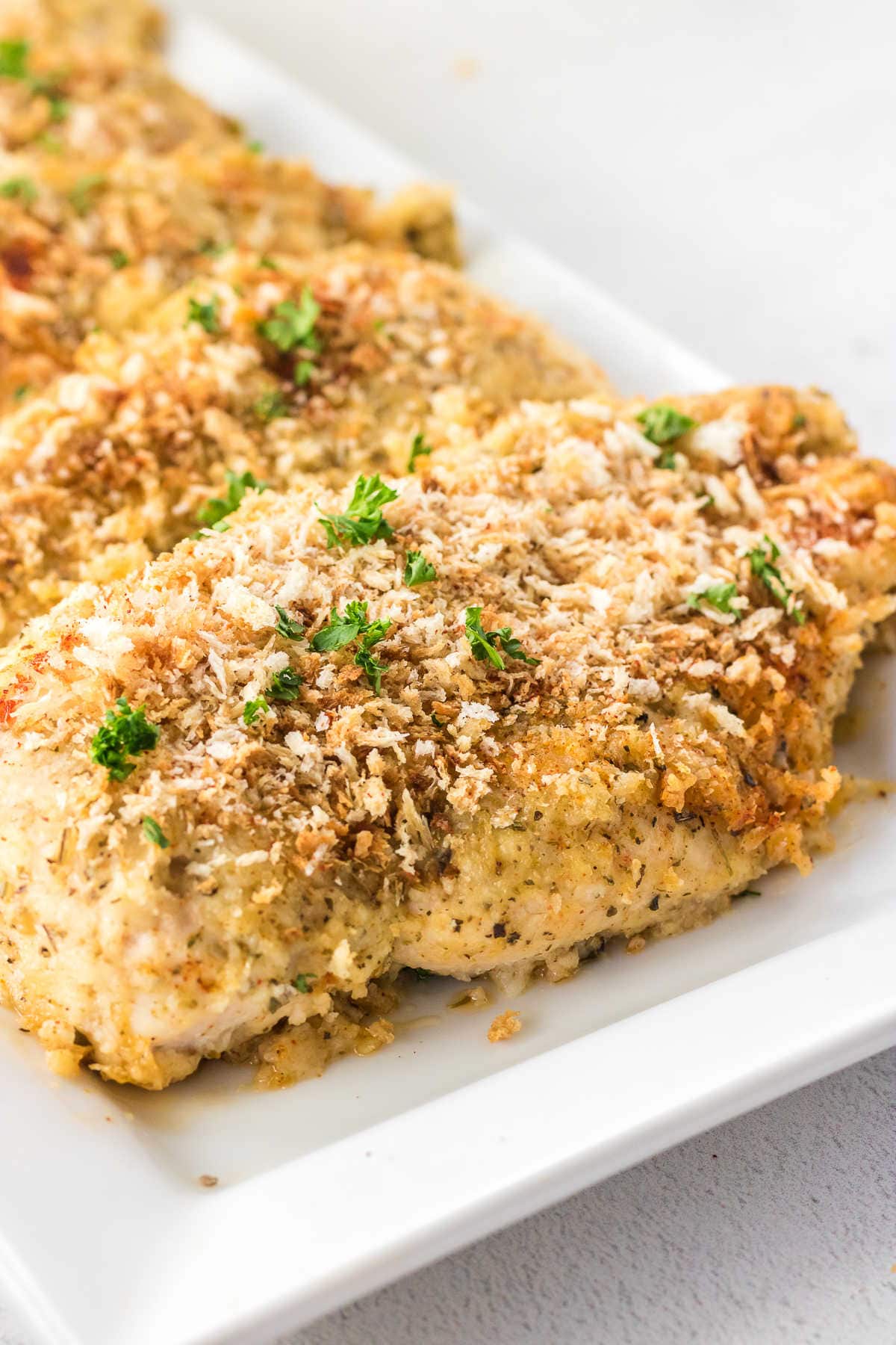 Breaded garlic parmesan chicken on a platter.