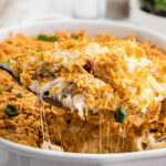 A closeup of a serving of the casserole showing gooey, melty cheese strings and the crunchy topping.