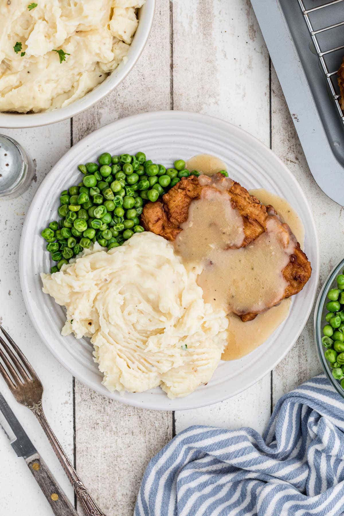 Overhead view of a plate of pork chops with mashed potatoes and gravy.