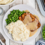 Overhead view of a plate of pork chops, peas, and mashed potatoes - feature image for this post.