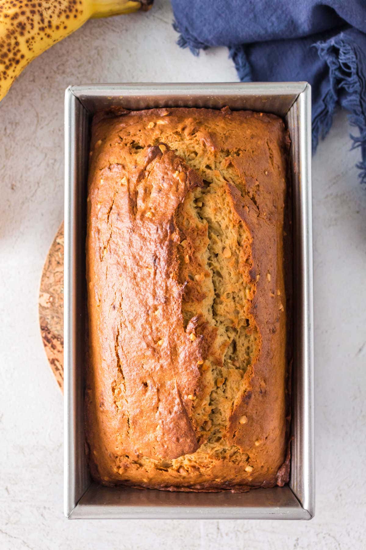 A loaf of peanut butter banana bread in a loaf pan. 