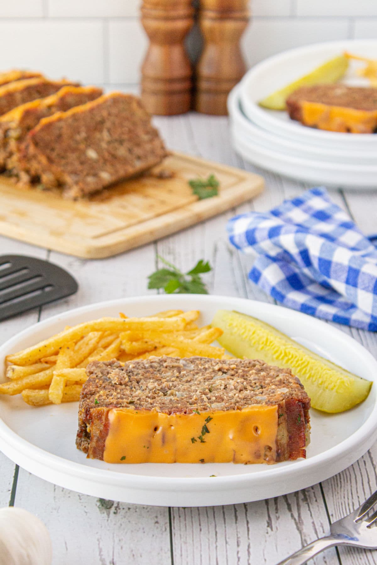 Slice of meatloaf on a plate with fries.