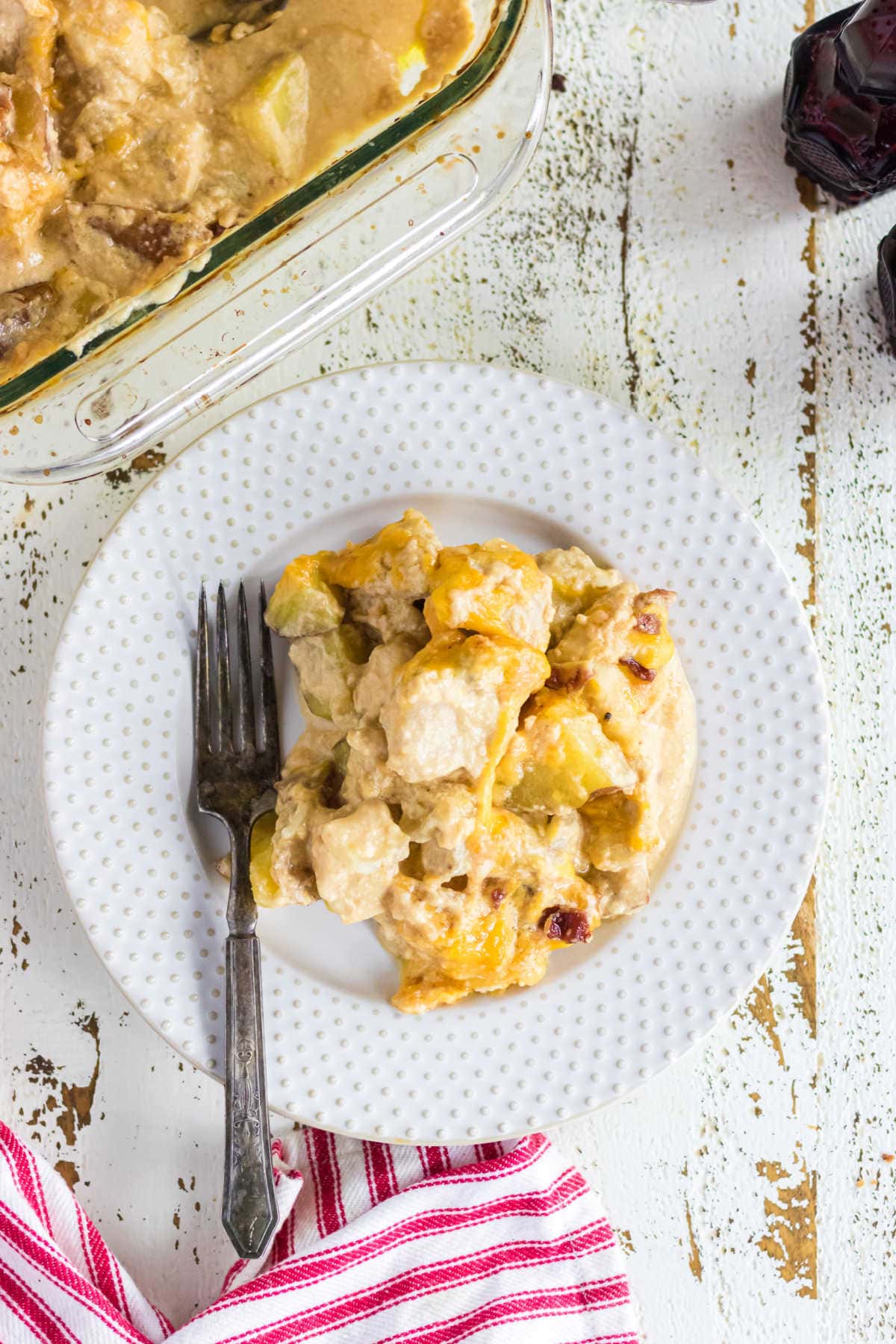 A white plate with a serving of casserole on it.