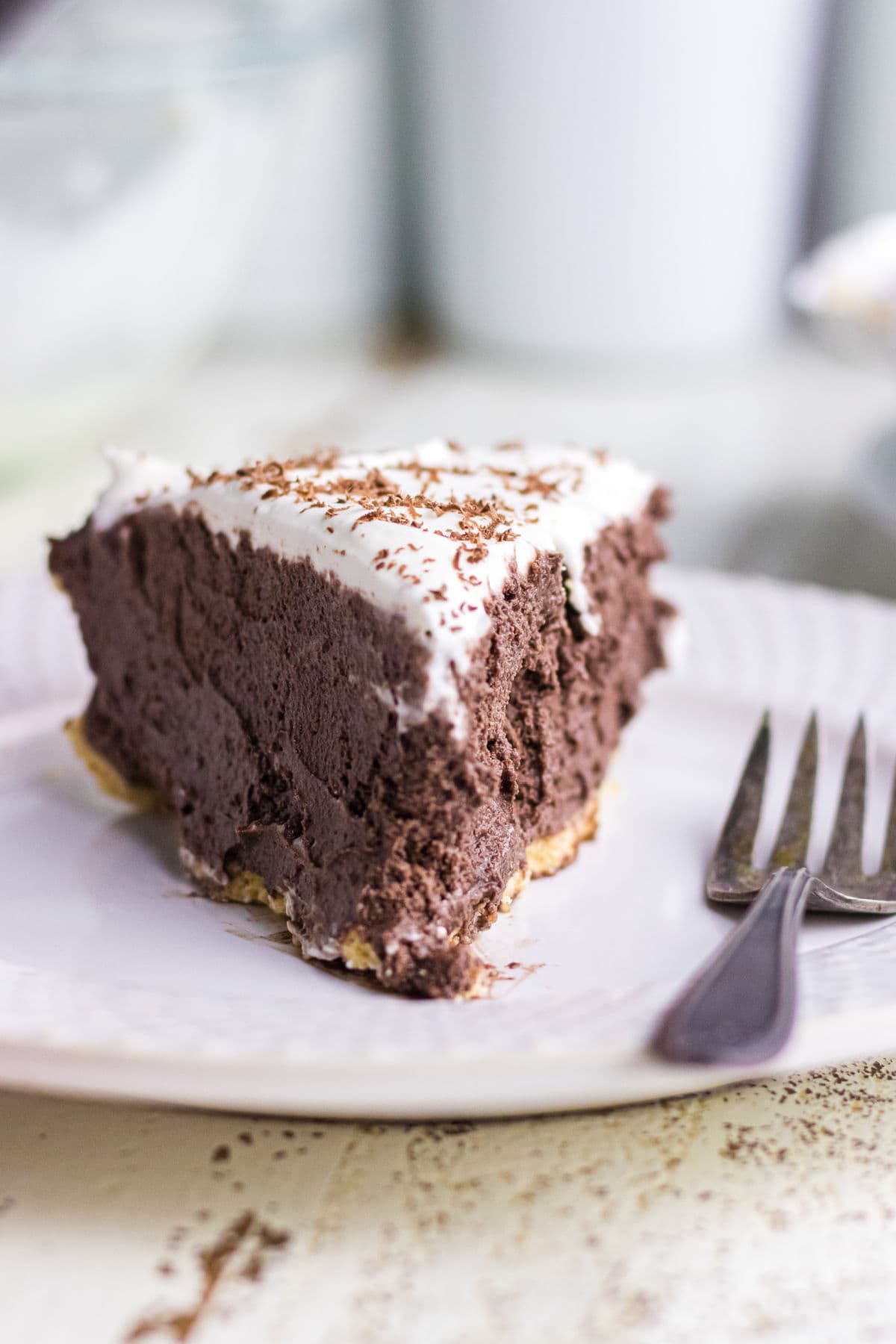 A slice of chocolate pie being served on a white plate.