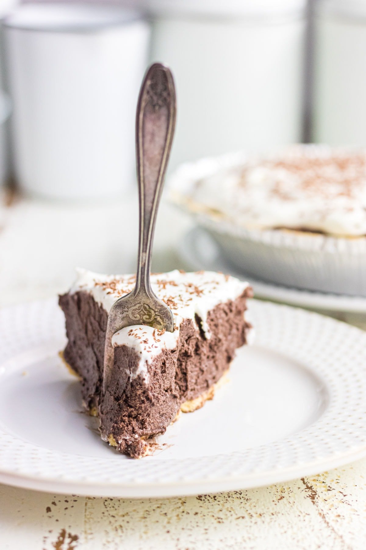 A slice of chocolate pie with a fork in it.