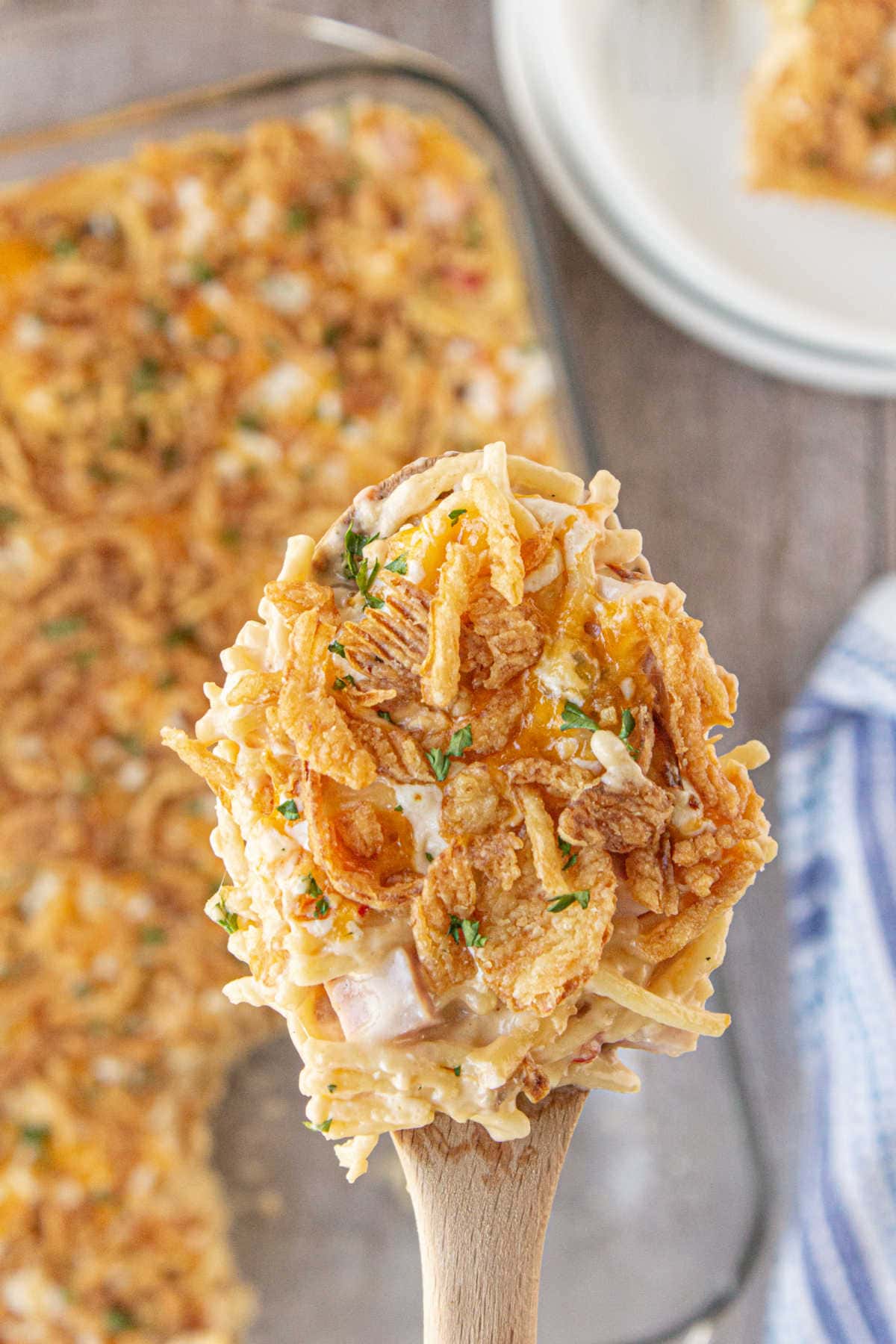 A serving of ham tetrazzini being lifted from the dish.