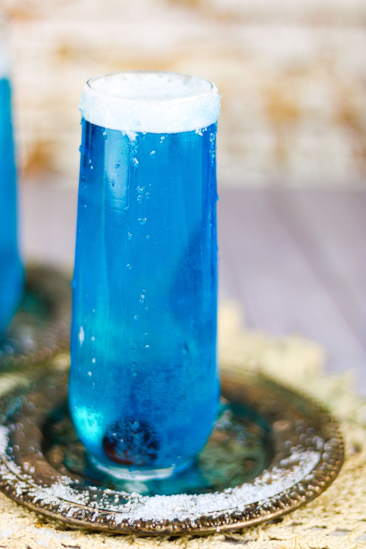 Deep blue cocktail in a champagne flute.
