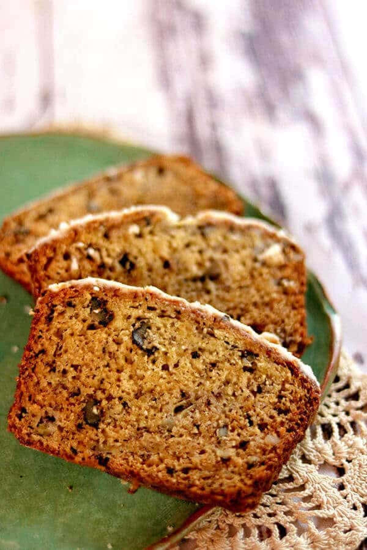 Slices of banana bread on a green plate.
