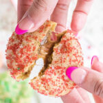 A cookie being broken in half showing the gooey insides with text overlay for Pinterest.