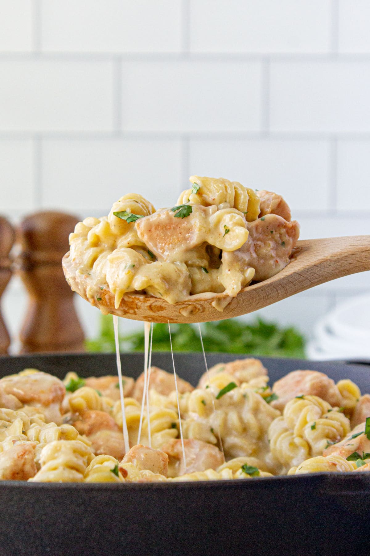 A serving of mac and cheese being spooned up from a pan.