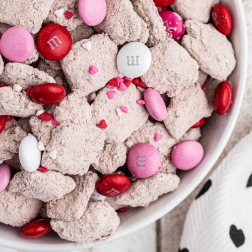 Close up of the snack mix showing pink, red, and white candy and red velvet covered Chex.