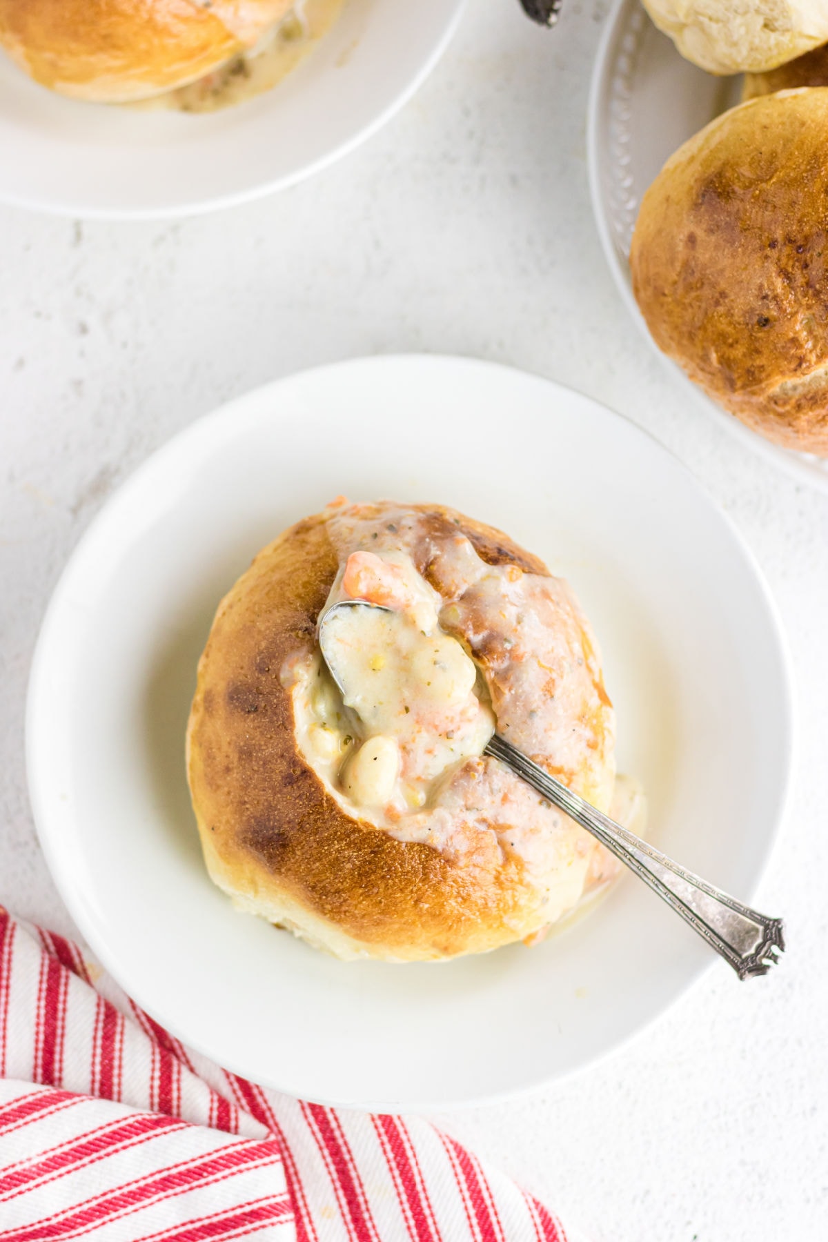 Overhead view of a golden brown bread bowl filled with creamy soup.