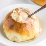 Closeup of a soup bread bowl filled with creamy chowder.