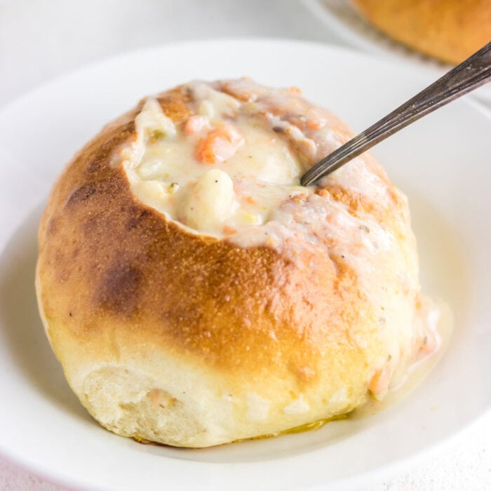 Closeup of a soup bread bowl filled with creamy chowder.