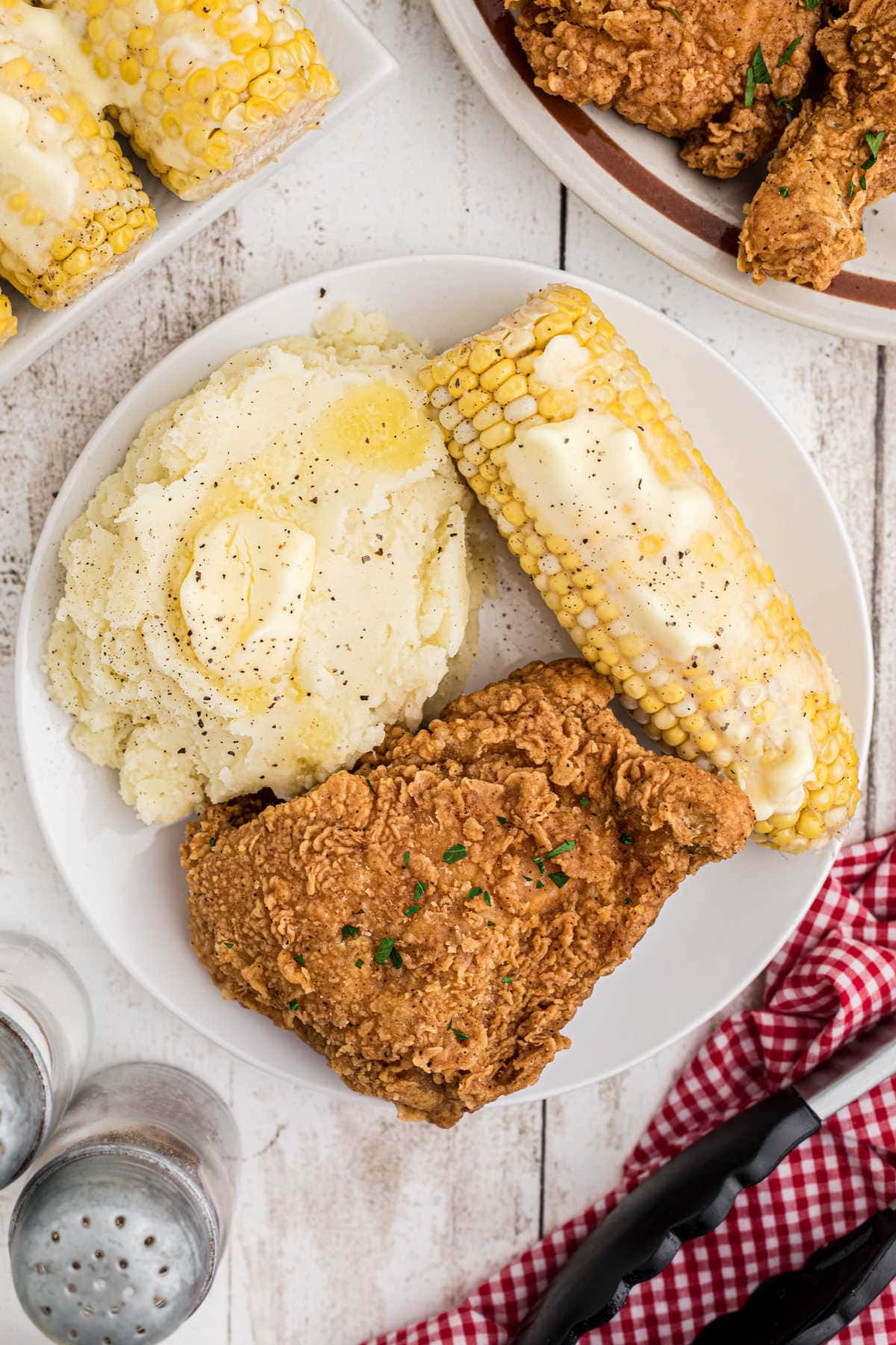 Overhead view of a plate with fried chicken, potatoes, and corn.