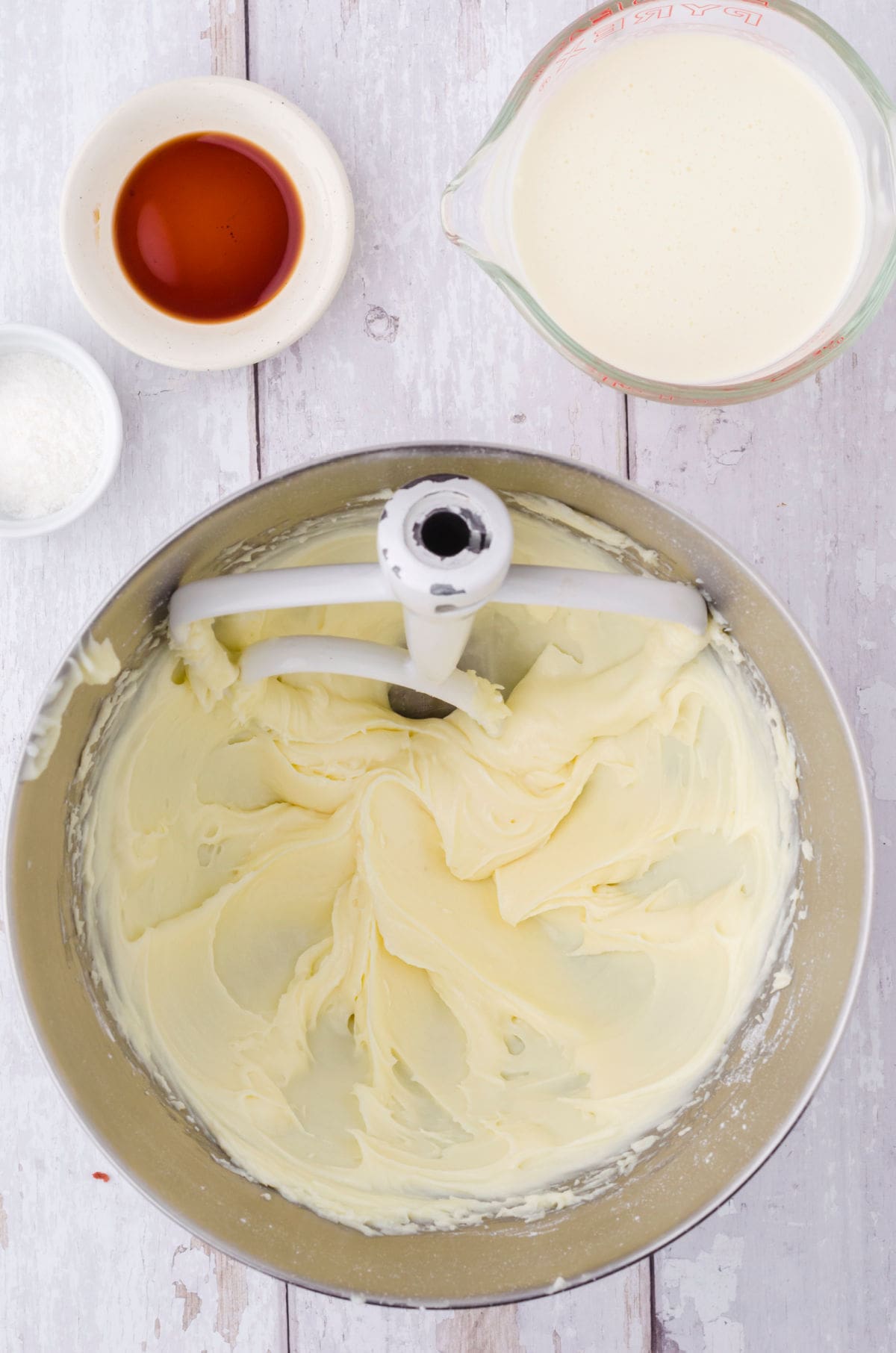 Cream cheese frosting being made in a bowl.