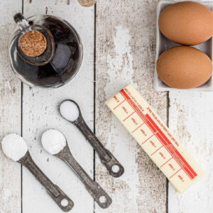 Measuring spoons filled with baking ingredients on a white table.