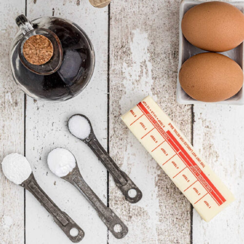 Measuring spoons filled with baking ingredients on a white table.