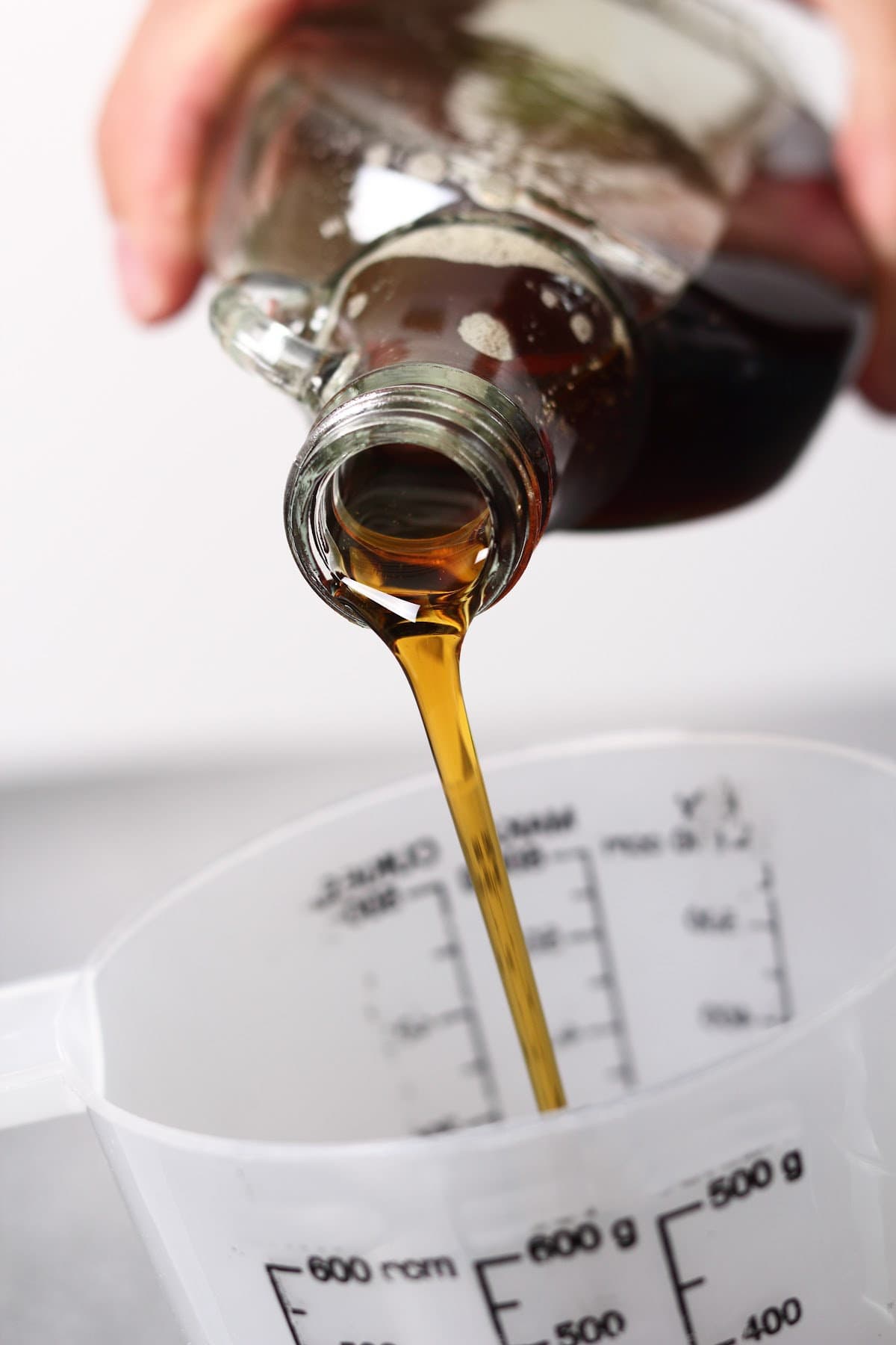 Pouring syrup into a measuring cup.