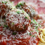 Meatballs in marinara on a plate with spaghetti. Text overlay for Pinterest.