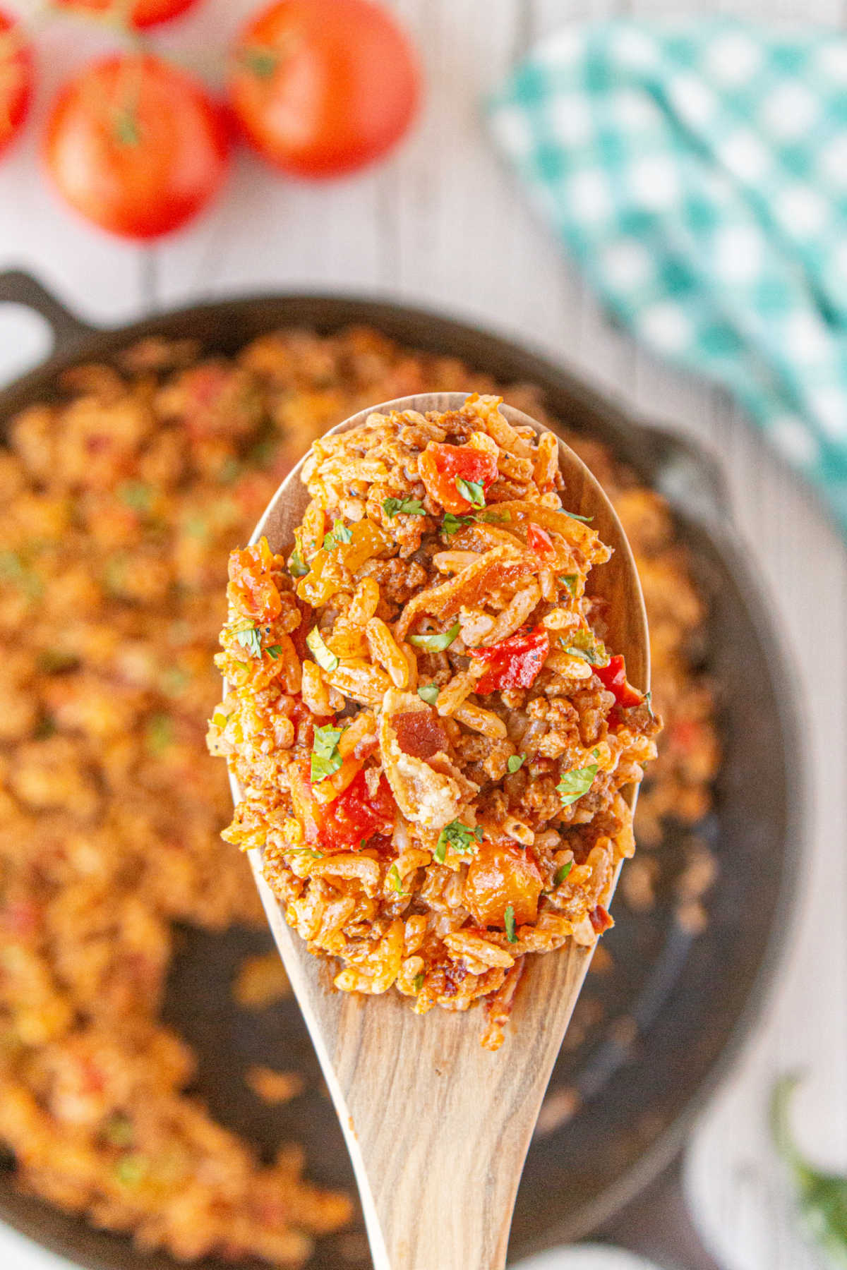 A spoonful of Spanish rice being lifted from the pan.