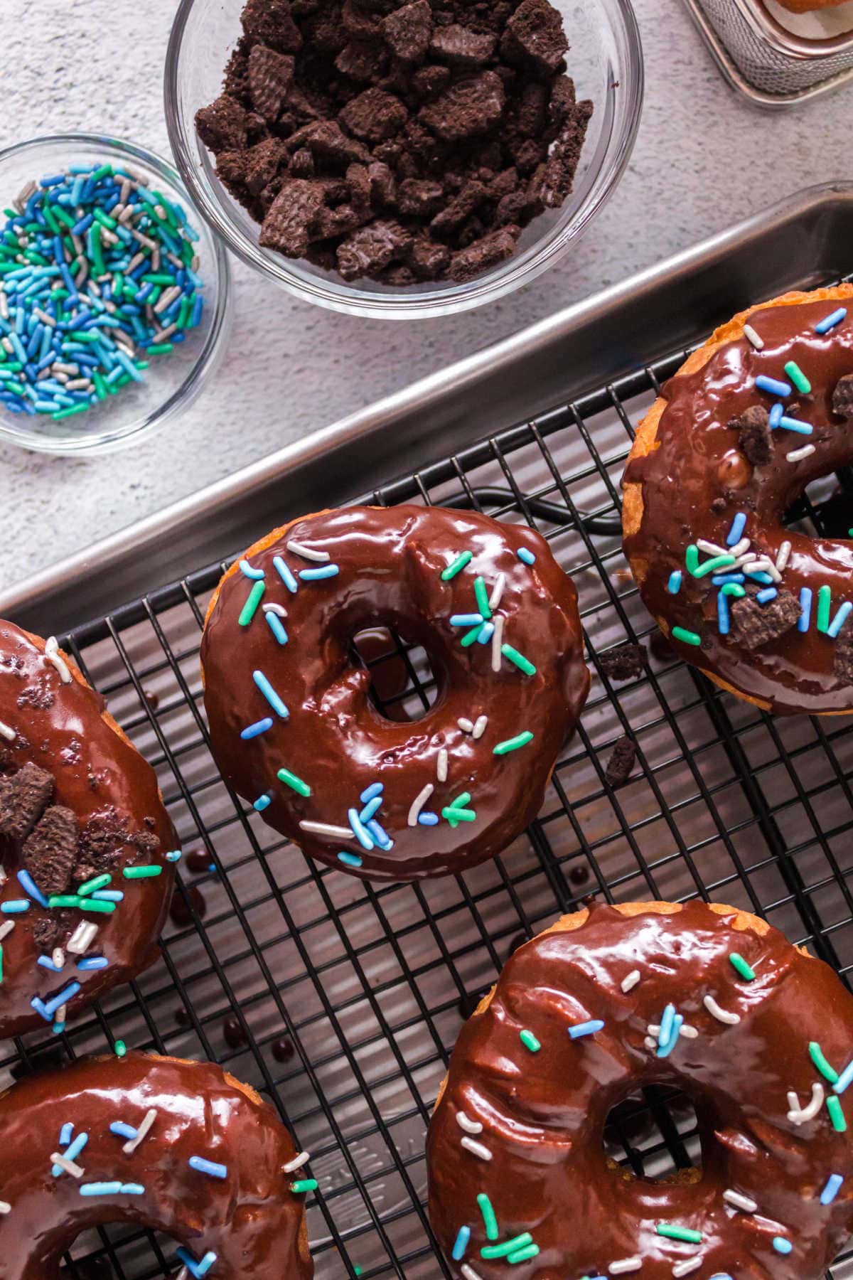 Chocolate frosted donuts on a cooling rack.