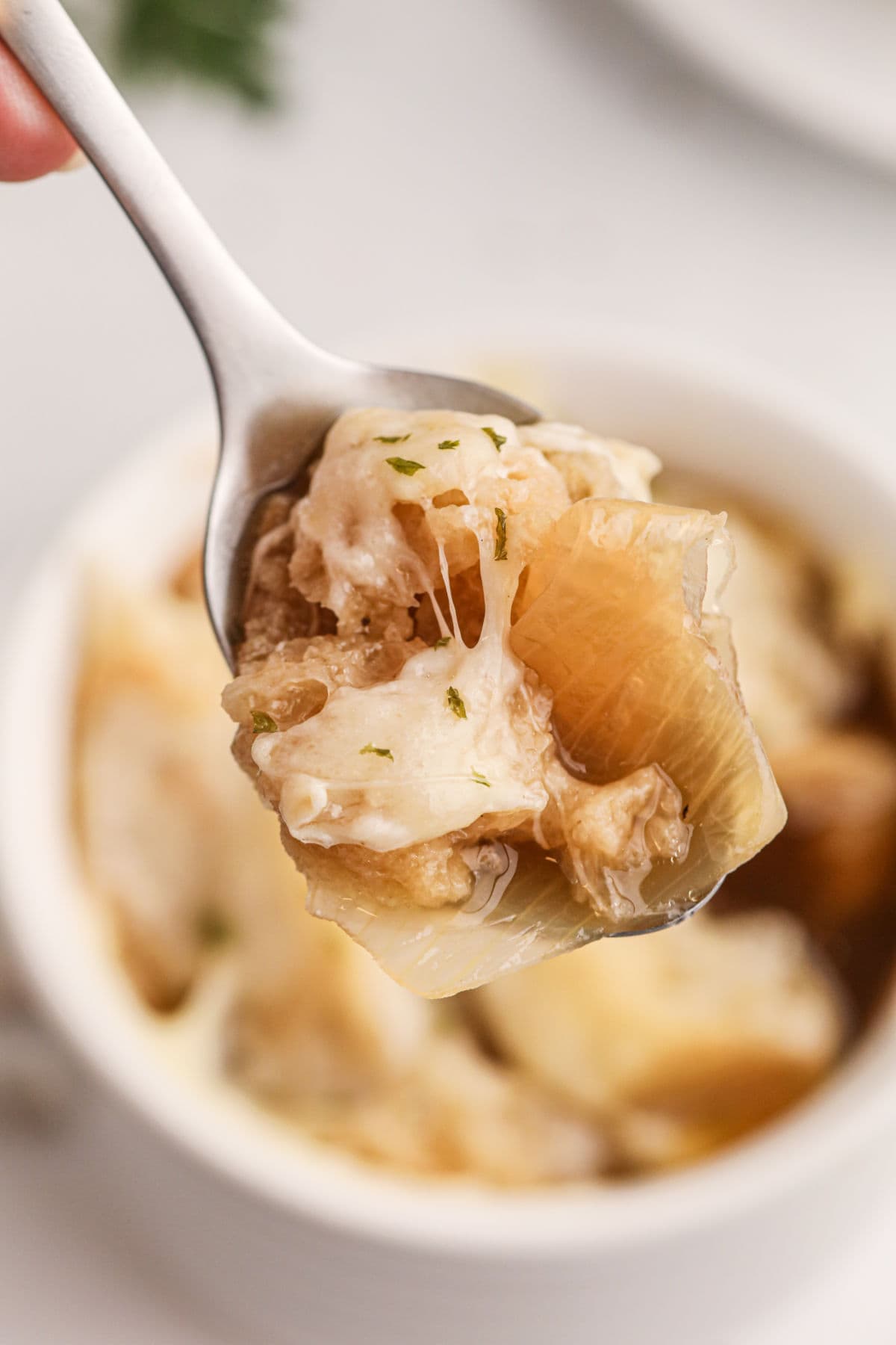 Closeup of a spoon in a bowl of soup.